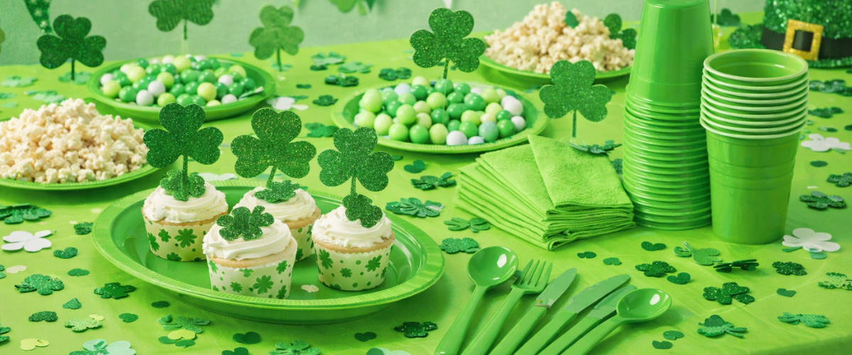 St. Patrick’s Day table and partyware with shamrock plates, green cups, and matching napkins