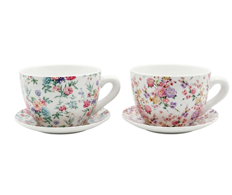 Two floral teacups with saucers on a white background