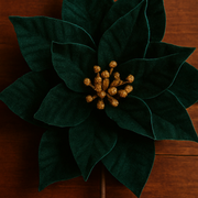 Artificial green poinsettia plant with gold center on a wooden surface