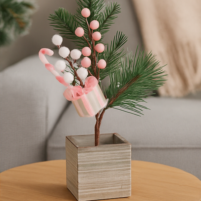 Decorative plant with pink and white berries in a wooden pot on a table.