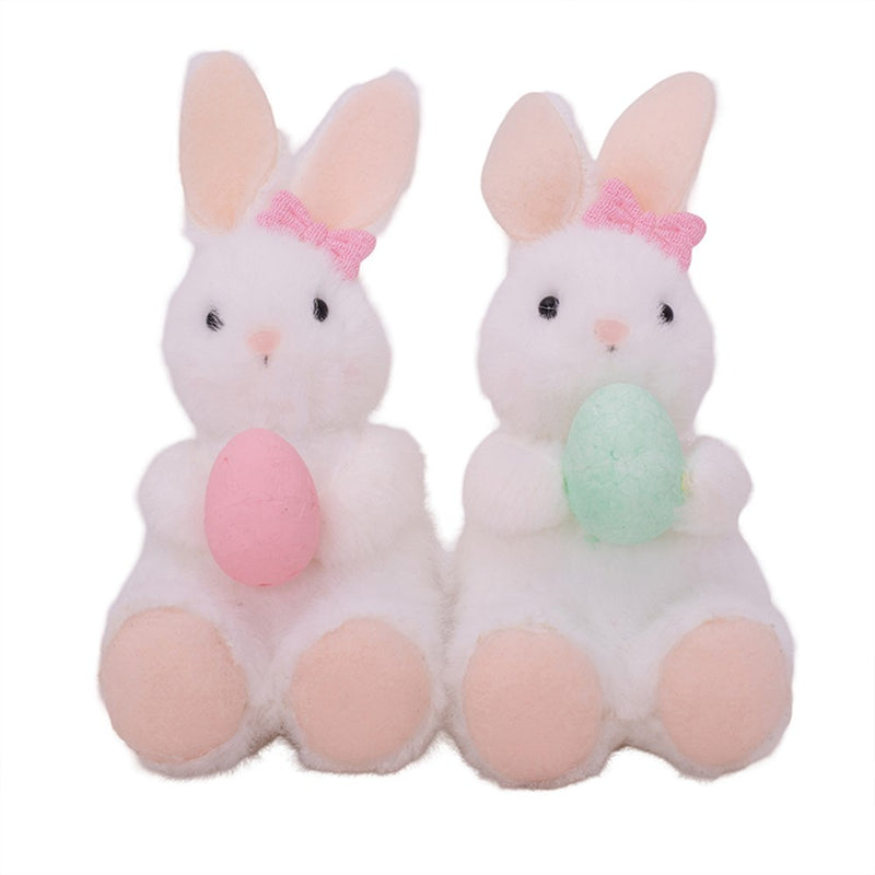 Small white bunny plush holding egg