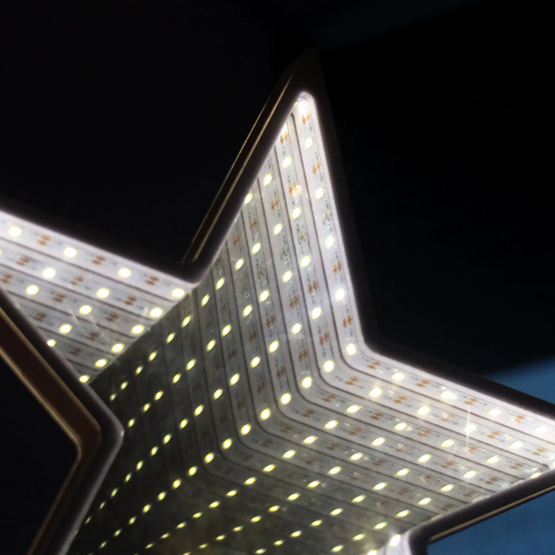 Infinity LED tree topper with glowing mirror light effect on a decorated Christmas tree