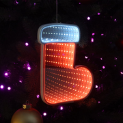 Infinity mirror Christmas boot with glowing LED lights hanging on a holiday-themed wall