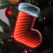 Infinity mirror Christmas boot with glowing LED lights hanging on a holiday-themed wall