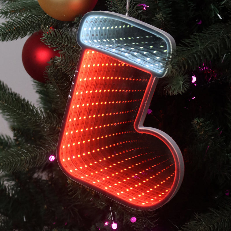 Infinity mirror Christmas boot with glowing LED lights hanging on a holiday-themed wall