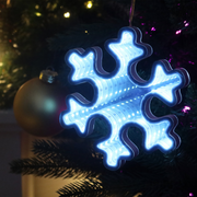 Infinity mirror snowflake decoration with glowing LED lights hanging in a festive indoor setting