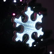 Infinity mirror snowflake decoration with glowing LED lights hanging in a festive indoor setting