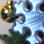 Infinity mirror snowflake decoration with glowing LED lights hanging in a festive indoor setting