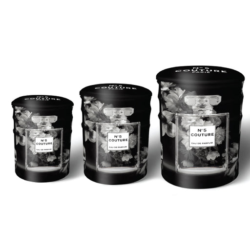 A set of three round tin ottomans featuring chic perfume and fashion designs.