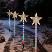 LED shooting star garden light glowing brightly in an outdoor lawn at night
