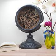 Black metal table clock with rotary gear design, 54cm tall