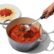 OXO Good Grips Polished Stainless Steel Slotted Spoon with deep slotted bowl and soft non-slip handle.