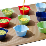 OXO Good Grips Silicone Baking Cups 12-Pack in assorted colours with non-stick interior and batter fill line.