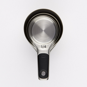 OXO Good Grips 4-Piece Stainless Steel Measuring Cup Set with etched markings, magnetic bases, and non-slip handles.