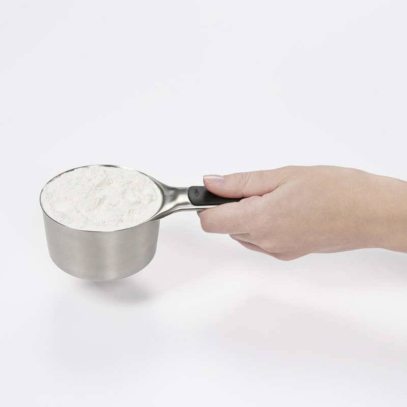 OXO Good Grips 4-Piece Stainless Steel Measuring Cup Set with etched markings, magnetic bases, and non-slip handles.