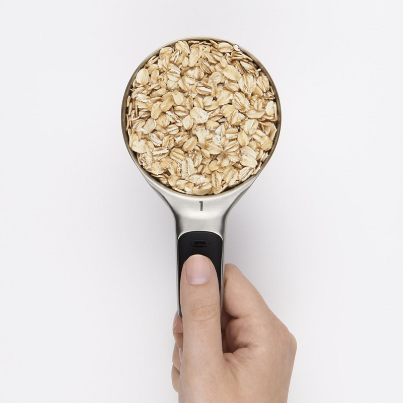 OXO Good Grips 4-Piece Stainless Steel Measuring Cup Set with etched markings, magnetic bases, and non-slip handles.