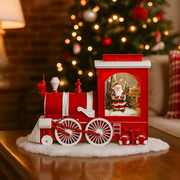 Vintage-style snowing Christmas train with LED lights and swirling snow effect around festive holiday scene