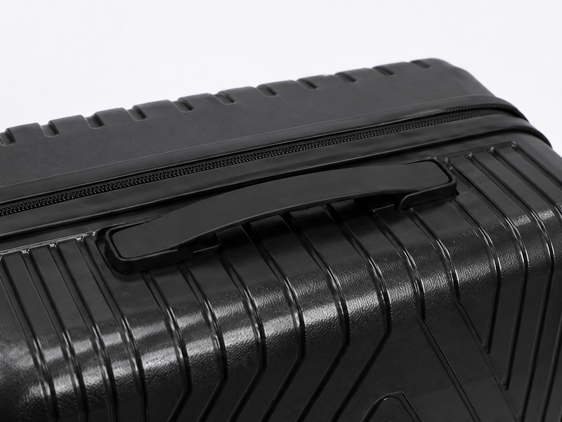 Close-up of a black textured suitcase with a handle on a light gray background