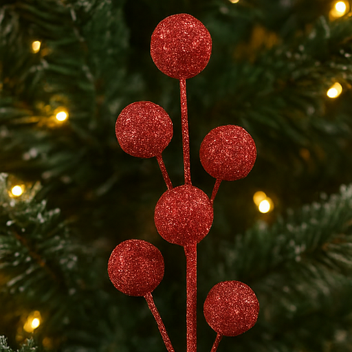 Red glittery berry branch decoration on a Christmas tree with blurred lights in the background