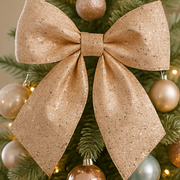 Gold glittery bow on a Christmas tree with gold ornaments.