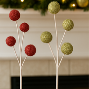 Decorative trees with red and green glittery spheres against a neutral background