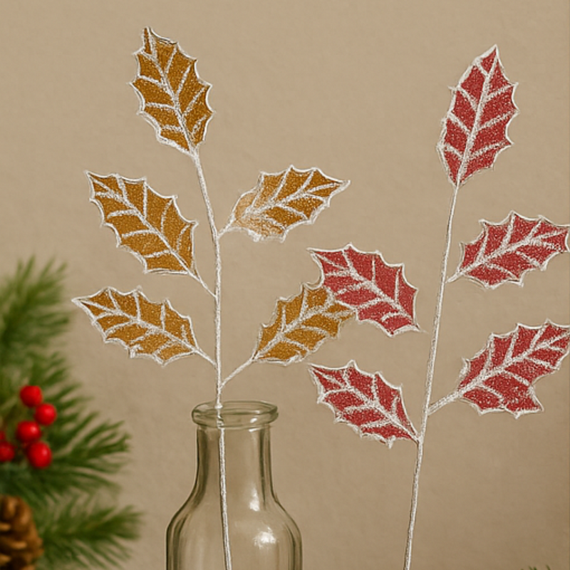 Decorative holly leaves with gold and red glitter on a beige background