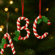 Decorative Christmas ornaments shaped like candy canes with letters 'A', 'B', and 'C' on a tree.