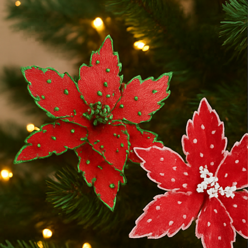 Red poinsettia decorations on a Christmas tree with blurred lights in the background