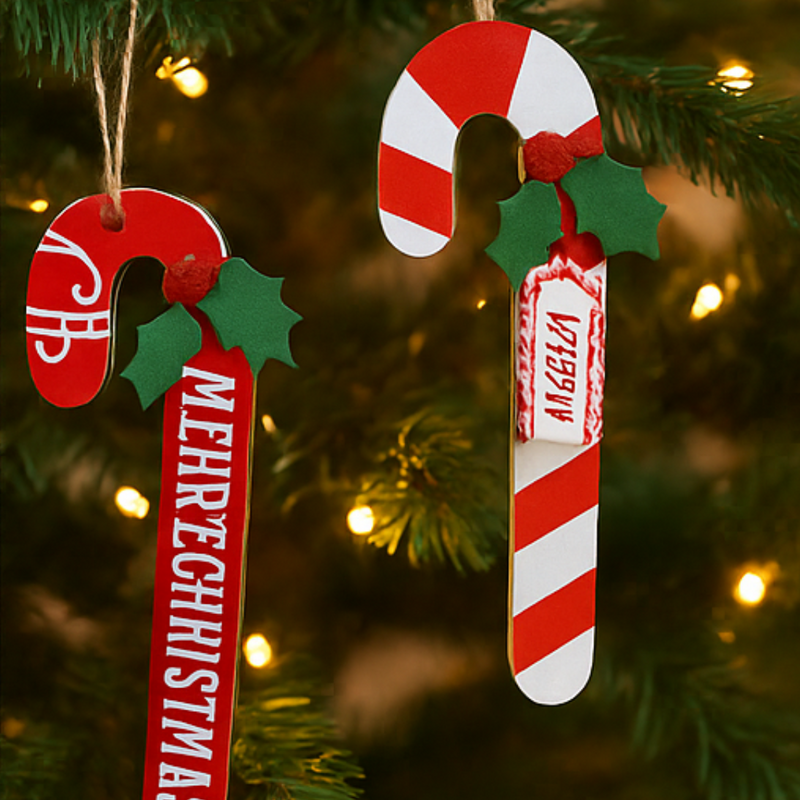 Candy cane-shaped ornaments with 'Mehreg' and 'Veggie' text on a Christmas tree.