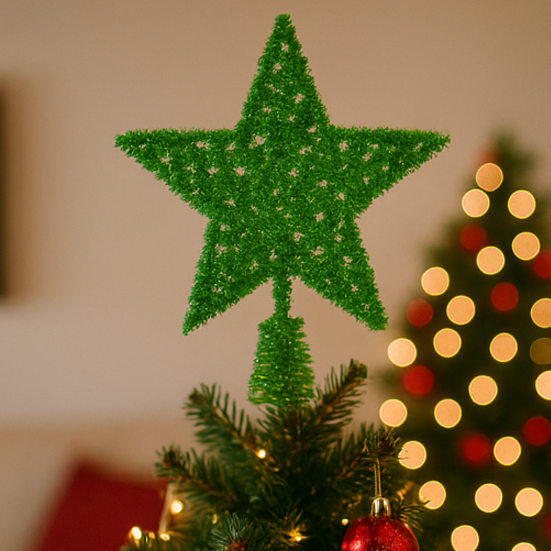 Green star-shaped Christmas tree topper on a decorated tree with blurred lights in the background.
