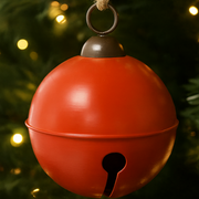 Red bell-shaped ornament with a dark brown top against a blurred Christmas tree background. – thumbnail