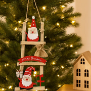 Decorative Christmas ornament with Santa Claus on a ladder against a Christmas tree background. – thumbnail