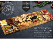 Magnetic acacia grazing board with ceramic dishes and cheese knives on a dark surface, featuring Rovis brand. – thumbnail