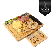 Wooden charcuterie board with assorted foods and utensils on a white background, featuring the Ronis brand. – thumbnail