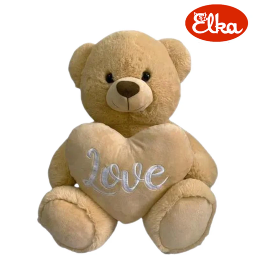 Beige teddy bear with a heart-shaped 'Love' pillow on a white background, featuring the Elka brand logo.
