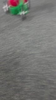 Dr. Seuss Grinch Musical Cruiser figurine with the Grinch riding a red scooter in a Santa suit, smiling mischievously.