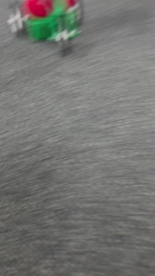 Dr. Seuss Grinch Musical Cruiser figurine with the Grinch riding a red scooter in a Santa suit, smiling mischievously.