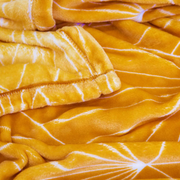 Celeste throw blanket 130x160cm in mustard colour on sofa – thumbnail
